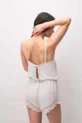Pijama de modal gris claro melange, compuesto por una musculosa de tirantes finos con detalle de encaje en el escote y un short con elástico en la cintura y terminación de encaje en las piernas.