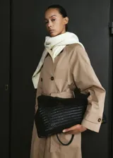 Gabardina larga color beige, de doble botonadura, con solapas amplias, mangas largas raglán, cinturón ajustable con hebilla y bolsillos laterales.