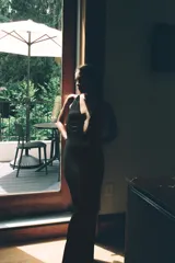 Vestido largo de punto negro con hilatura de viscosa, escote en pico pronunciado con abertura central, tirantes finos cruzados en la espalda y diseño fluido.