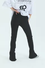 Calza negra de lycra gruesa, tiro alto y corte semi-oxford con abertura en el tobillo.