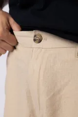 Bermuda de lino color beige, de corte recto y diseño relajado, con cintura elástica y bolsillos laterales.