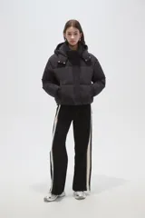 Campera puffer negra con capucha, manga larga, cierre frontal y cuello alto.