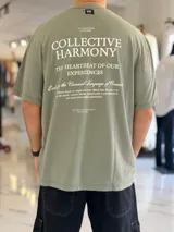 Remera oversize de color verde militar, con gran estampado tipográfico blanco en la espalda y mangas cortas.