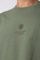 Remera oversize de algodón premium color verde militar, con estampado minimalista en el frente y una gráfica protagonista en la espalda.