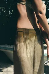 Pantalón de tiro medio con diseño estampado, confeccionado en viscosa. Presenta pliegues en la parte delantera y cierre lateral con cremallera oculta.