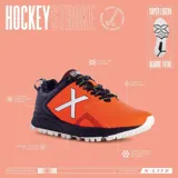 Championes deportivos Munich modelo Stroke 04, diseñados para hockey, con combinación de colores naranja y negro. Presentan el logo característico de la marca en blanco en el lateral, suela con relieve para mayor tracción y cordones negros.