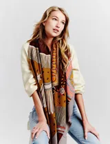 Pashmina rectangular con estampado multicolor en tonos tierra, naranja, verde y amarillo. Presenta motivos geométricos y florales en secciones definidas.