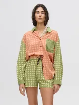 Short de corte boxy confeccionado en viscosa con estampado geométrico de estrellas en tonos rosados. Presenta una pretina elástica en color naranja y cordón de ajuste en color marrón.