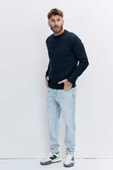 Pantalón de jean corte regular, color celeste claro, con diseño de cinco bolsillos y cierre frontal con botón y cremallera.