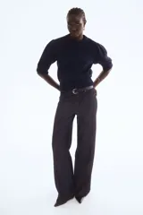 Top de punto acanalado en color azul marino, con cuello redondo, mangas cortas abullonadas y terminaciones acanaladas en puños y ruedo.