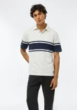 Polo de manga corta color blanco con franjas horizontales en azul marino en el pecho y las mangas. Cuenta con cuello clásico y cierre frontal de botones.