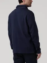 Buzo de algodón orgánico azul marino con cuello camisero, manga larga y medio cierre abotonado con solapa tapada.