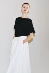 Top de punto negro con diseño holgado, escote bote y mangas cortas estilo murciélago, con ribete ancho en la cintura.
