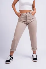 Pantalón mom jean color beige, de tiro alto, con bolsillos delanteros y traseros, y ruedo doblado.