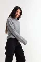 Sweater de tejido de punto acanalado en color gris, con cuello alto y mangas largas con diseño oxford acampanado.