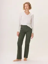 Remera blanca de manga larga con escote en V y detalles de alforzas verticales en el frente.