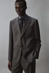 Blazer de corte regular fit en color gris, con solapas de muesca, cierre frontal de un botón y bolsillos con solapa en la cadera.