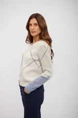 Sweater de punto con cuello en V y diseño de rombos en tonos beige, azul y blanco. Presenta mangas largas con puños ajustados y corte clásico.