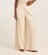 Pantalón pantalona de viscosa color crudo, con trabillas en la cintura, pliegues delanteros y bolsillos cargo utilitarios en los laterales.