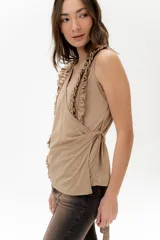 Musculosa cruzada con escote en V, confeccionada en una mezcla de lyocell y algodón. Presenta un diseño envolvente que se ajusta mediante lazos y cuenta con volados decorativos en 3D que recorren el frente y los hombros.