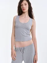 Pantalón de dormir de corte recto y holgado, confeccionado en tejido suave con textura acanalada. Presenta cintura elástica con cordón ajustable y bolsillos laterales.