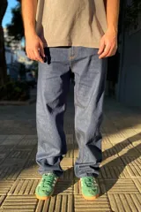 Pantalón de jean azul oscuro con corte baggy y calce relajado. Presenta cinco bolsillos clásicos y costuras reforzadas en tono contrastante.