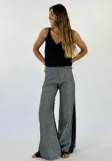 Pantalón gris de corte palazzo con aberturas laterales en el ruedo.