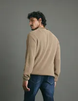 Remera de punto tipo polo con textura waffle, color verde petróleo, de manga larga y cuello con cierre de botones.