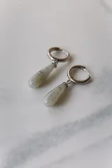 Aros colgantes de acero quirúrgico plateado con dije de piedra natural rosa en forma de lágrima.