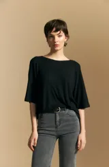 Remera de calce relajado con silueta fluida, confeccionada en tejido de viscosa con elastano. Presenta cuello redondo, mangas cortas y un diseño minimalista de caída suave.