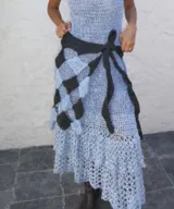 Culero tejido a mano en crochet con diseño de damero en tonos celeste y marrón, con faja ajustable anudable en la cintura.
