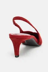 Zapato de tacón destalonado color rojo, con acabado en punta y tacón fino de 6 cm. Presenta pespunte en la parte delantera y tira trasera con pieza elástica lateral.
