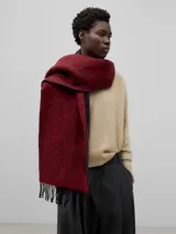 Bufanda rectangular color rojo oscuro con textura y flecos en los extremos.