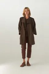 Tapado de largo medio, abierto, con cuello y diseño de mangas amplias. Confeccionado en lana fina sin teñir, con terminaciones envivadas en los bordes.