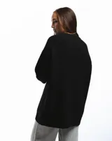 Sweater negro de punto con cuello redondo y corte holgado. Diseño con motivo de zurcido en la manga izquierda.
