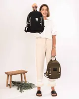 Mochila de nylon color verde oliva, con compartimento principal y bolsillo frontal con cierre metálico. Presenta detalles de cordones decorativos en los tiradores de los cierres, una grifa de goma con el logo de la marca y correas ajustables.