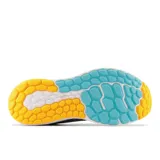 Championes de running New Balance Fresh Foam X Vongo v5, color gris con detalles en celeste y amarillo.