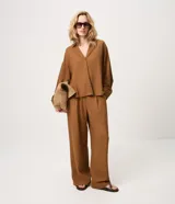 Pantalón wide leg de corte amplio y fluido, confeccionado en mezcla de viscosa y lino. Presenta pinzas en la parte delantera y cintura elastizada en la espalda.