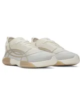 Championes de entrenamiento Under Armour modelo W Sculpt TR, color blanco con detalles en beige. Presentan una parte superior de micromalla transparente con diseño abstracto impreso en 3D, lengüeta de una sola pieza y entresuela de EVA con suela de goma.