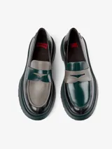 Mocasín Camper Twins de cuero negro con detalle de antifaz verde y gris.