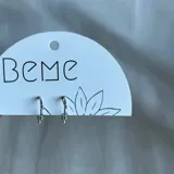 Par de aros argolla plateados con tres bolitas decorativas.