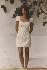 Vestido mini de escote cuadrado y mangas cortas abullonadas, con estampado de lunares. Cuenta con espalda descubierta con detalle de tiras ajustables y cierre lateral oculto.