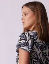 Remera tejida con estampado animal print, de manga corta con detalle de puntilla en las mangas y cuello redondo.