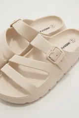 Sandalias de goma color negro con diseño de tres tiras cruzadas y hebilla lateral ajustable.