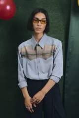 Camisa de manga larga en color celeste, con canesú frontal destacado que presenta un estampado paisajístico. Posee cuello clásico, cierre frontal con botones y puños simples.