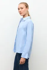 Camisa de lino color celeste melange, de corte clásico con cuello camisero y manga larga.