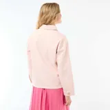 Chaqueta tipo sobrecamisa de denim en color rosa, con cuello clásico, cierre frontal de botones metálicos y dos bolsillos de parche delanteros.
