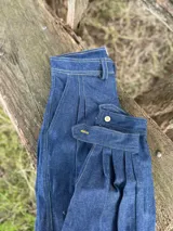 Pantalón de jean azul oscuro, de corte recto, con bolsillos laterales y traseros.