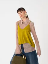 Top de viscosa color mostaza con escote en V y breteles finos regulables. Presenta un diseño minimalista de corte holgado y caída fluida.