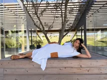 Vestido midi de punto color blanco, confeccionado en algodón, con mangas cortas, aberturas laterales y bolsillos aplicados de cuero marrón con detalles bordados a mano.